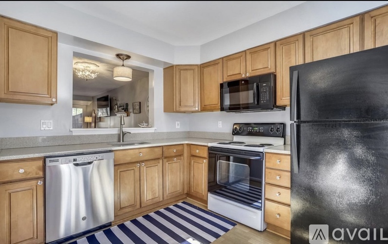 A kitchen with wooden cabinets and a black refrigerator.