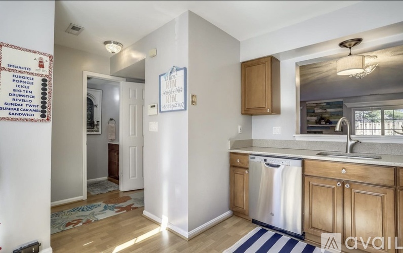 A kitchen with wooden cabinets and a white dishwasher.