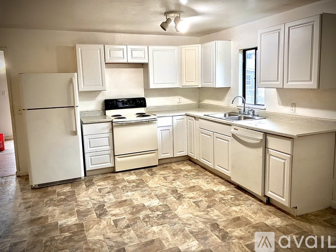 A kitchen with white appliances and cabinets.