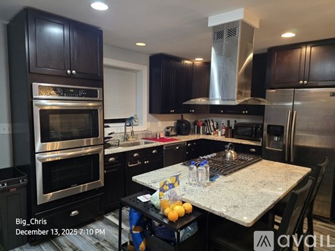 A kitchen with a granite countertop and stainless steel appliances.