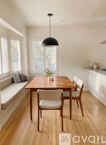 A dining room with a wooden table and chairs.