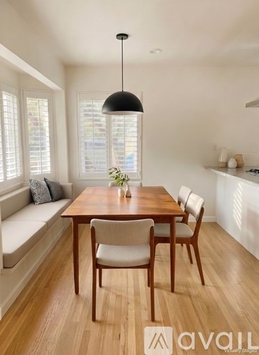 A dining room with a wooden table and chairs.