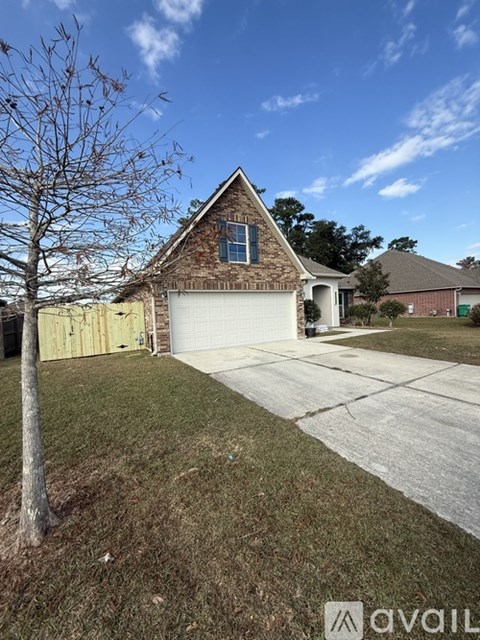 A house with a garage and a tree in front.