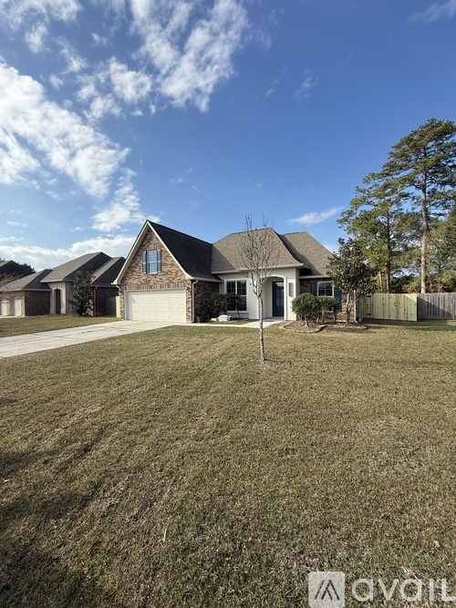 A house with a brown roof and a white garage door is surrounded by a grassy lawn.