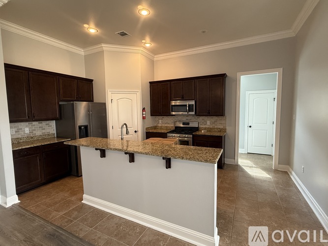 A kitchen with brown cabinets and a granite countertop.