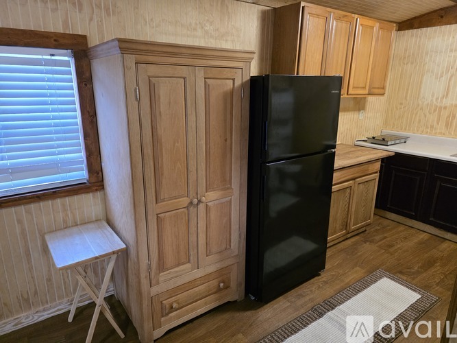 A small kitchen with wooden cabinets and a black toaster on the counter.