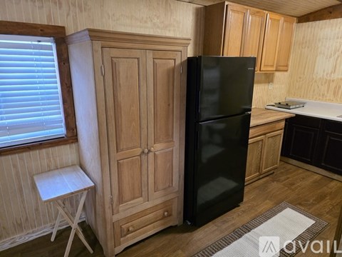 A small kitchen with wooden cabinets and a black toaster on the counter.