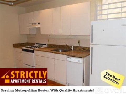 A kitchen with a refrigerator and a stove top oven.