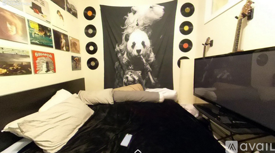 A person is lying on a bed with a poster of a woman's face on the wall behind them.