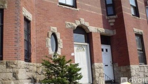 A red brick building with a white door and windows.