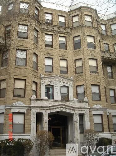 A large, old building with many windows and a balcony in front.