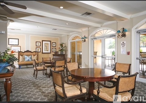A dining room with a round table surrounded by chairs.