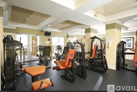 A gym with orange chairs and black equipment.