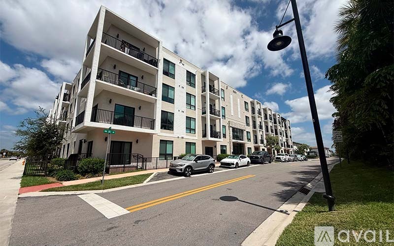 A street view of a residential area with apartment buildings and parked cars.