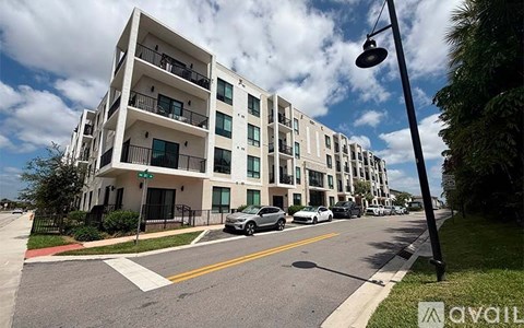 A street view of a residential area with apartment buildings and parked cars.