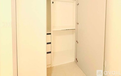 A white closet with a door open and a shelf.