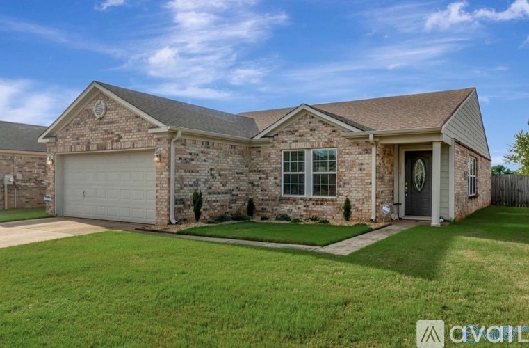 A house with a stone facade and a grey roof is for sale.