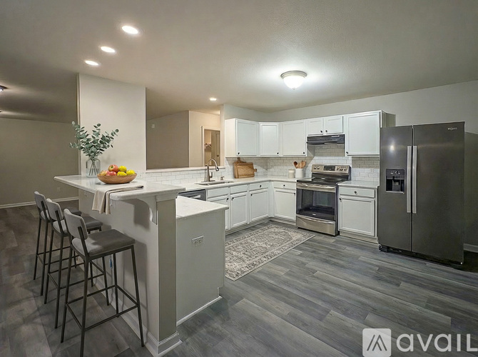 A modern kitchen with a white island and stainless steel appliances.