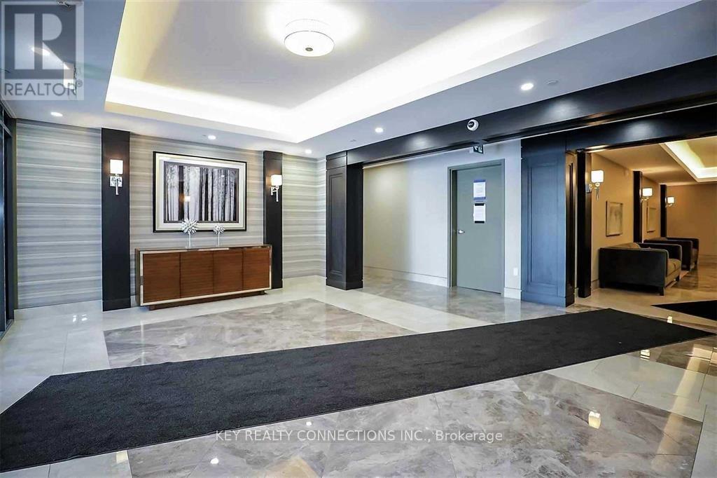 A hallway with a black carpet and a white ceiling.