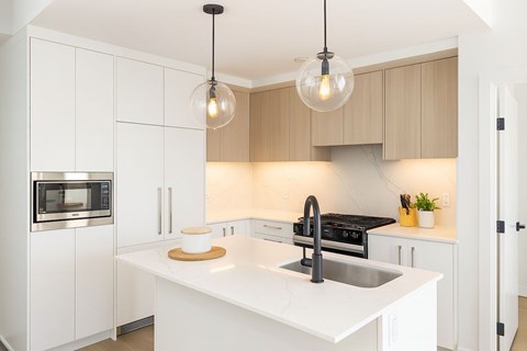 A modern kitchen with a white countertop and a black stove.
