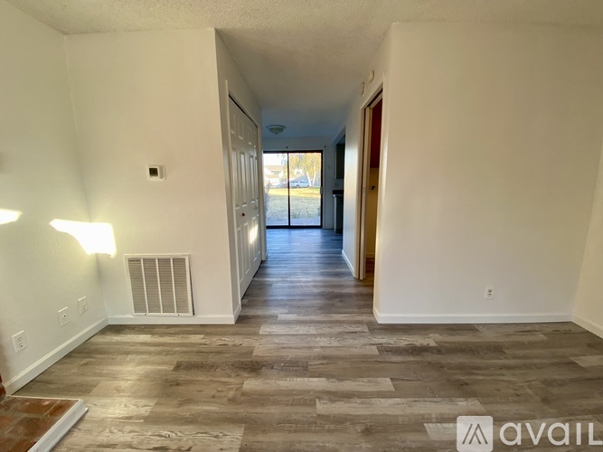 A long hallway with a tiled floor and a door on the right.