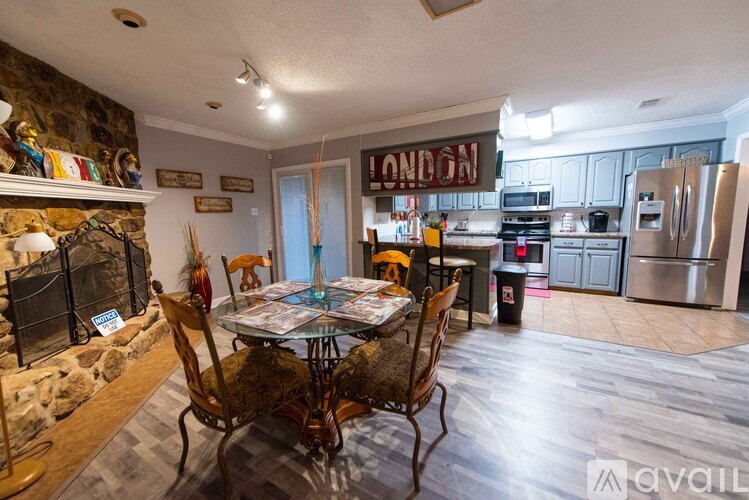 A kitchen with a table and chairs in front of a fireplace.