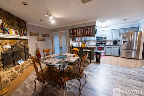 A kitchen with a table and chairs in front of a fireplace.