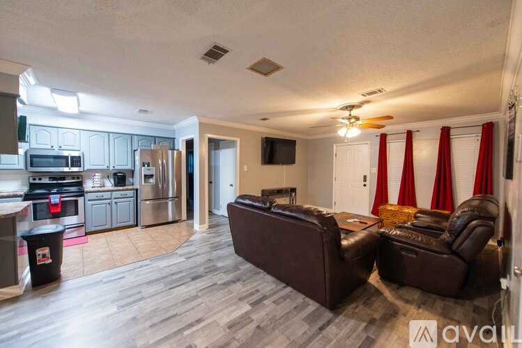 A living room with a brown couch and a television on the wall.