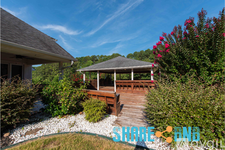 A house with a gazebo in the backyard.