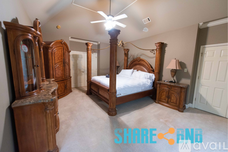 A bedroom with a four poster bed and a dresser.