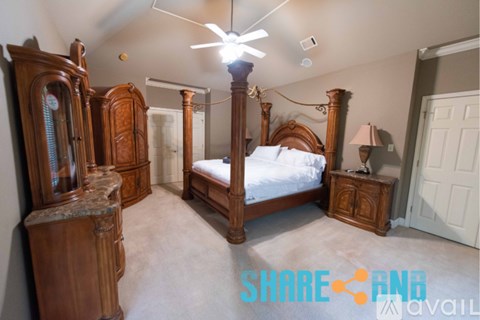 A bedroom with a four poster bed and a dresser.