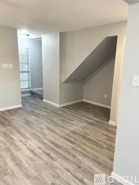 A room with a wooden floor and a staircase.