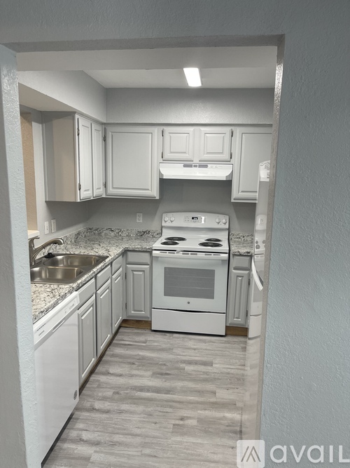 A kitchen with white cabinets and a stove top oven.