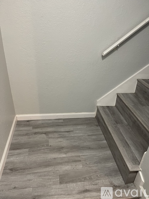 A staircase with wooden steps and a metal handrail.