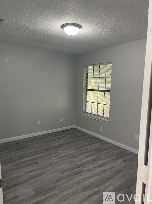 A room with a window and wooden flooring.