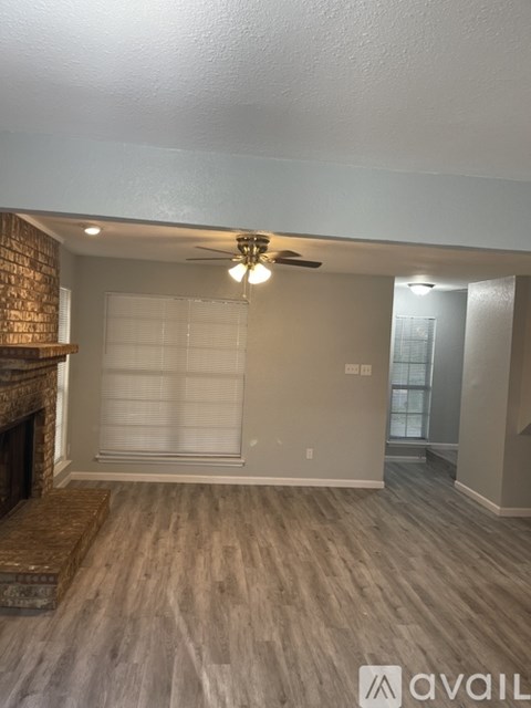A room with a fireplace and a ceiling fan.