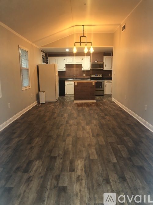 A kitchen with a refrigerator and a dining table.