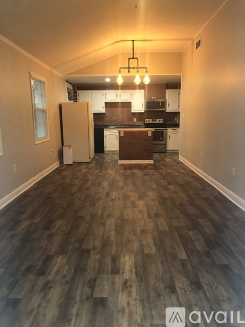 A kitchen with a refrigerator and a dining table.