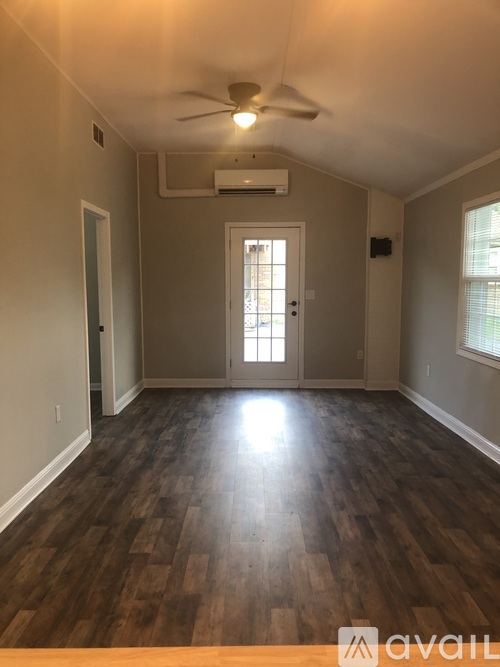 A room with wooden floors and a ceiling fan.