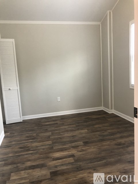 A room with wooden flooring and a white door.