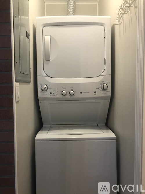 A white washing machine is sitting in a small space.