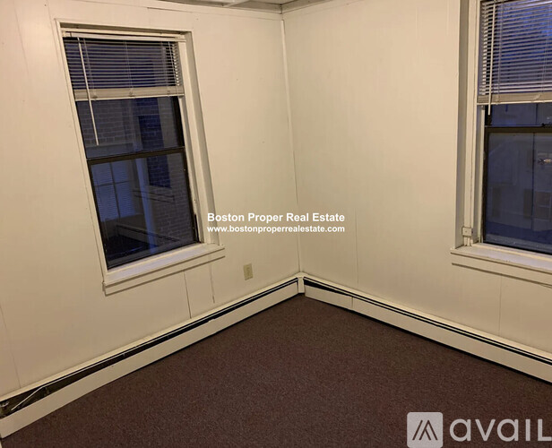A room with a window and a carpeted floor.