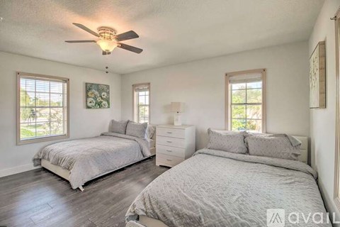 A bedroom with two beds and a ceiling fan.