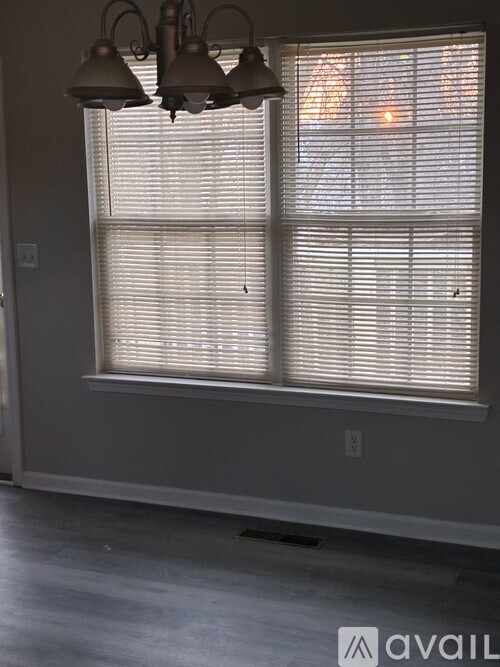 A window with blinds and a light fixture above it.