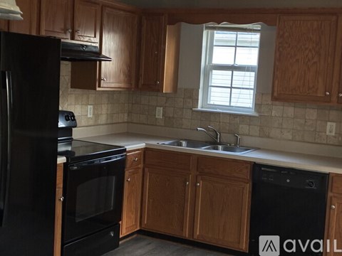 A kitchen with wooden cabinets and black appliances.