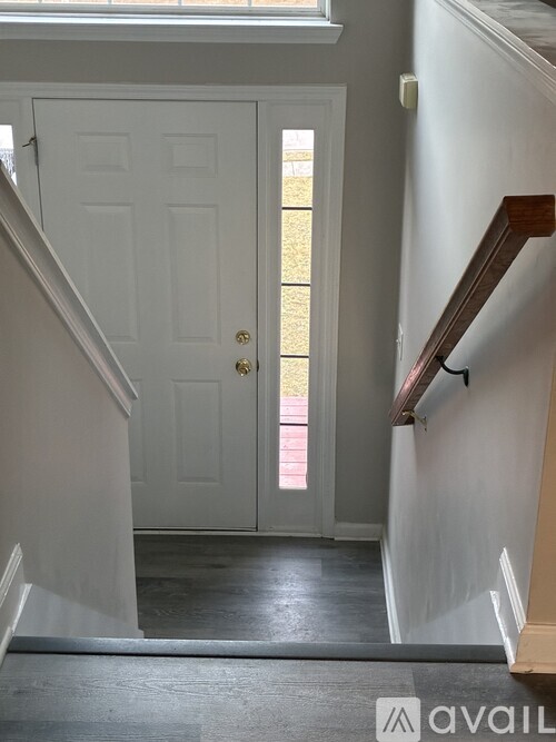 A white door is at the end of a hallway.