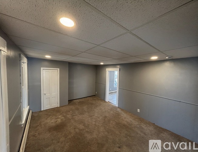 A room with grey walls and carpeted floor.