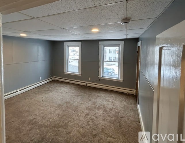 A room with grey walls and carpeted floor.