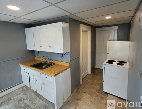 A kitchen with white cabinets and a wooden countertop.