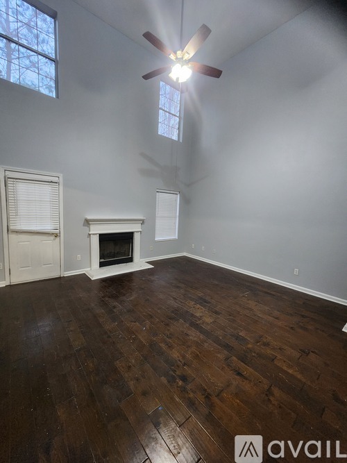 A room with a fireplace and wood flooring.